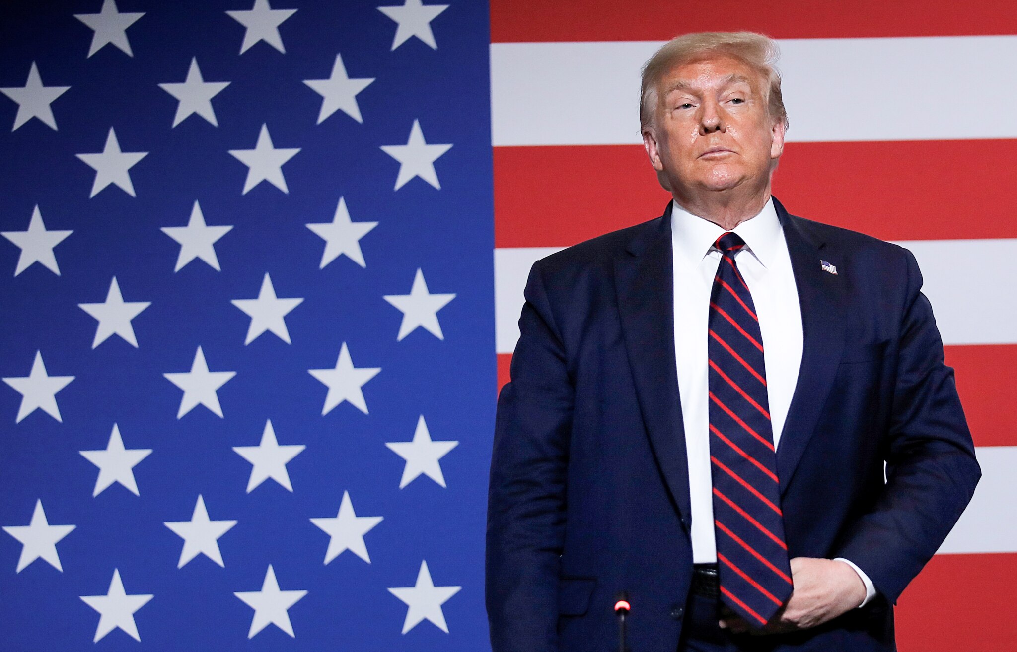 唐纳德·特朗普站在美国国旗前拿着皮带扣